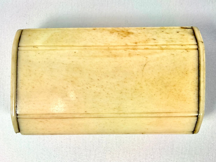 Early 19th-century bone snuff box with warm polished patina, natural discoloration, and intricate Masonic symbolism.