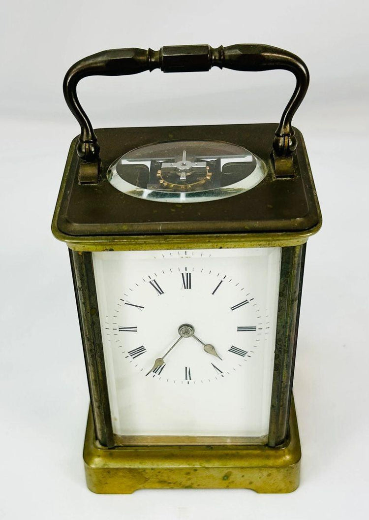 Elegant antique French brass carriage clock with beveled glass panels, white enamel dial with Roman numerals, and visible escapement through the top panel, stamped with a “B” in a circle attributed to Jules Bunelot, circa late 19th century.