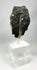 Side view of Gandharan Buddha head fragment revealing carved hair detail and ancient surface patina