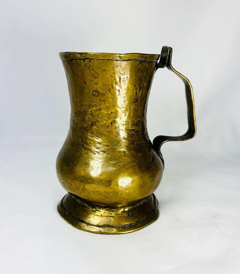 18th-century George II brass baulster tankard from England, circa 1727–1760. Cylindrical body with single handle, lidless design, and natural patina. Classic Georgian drinkware reflecting everyday use in taverns and homes, combining practicality and period craftsmanship.
