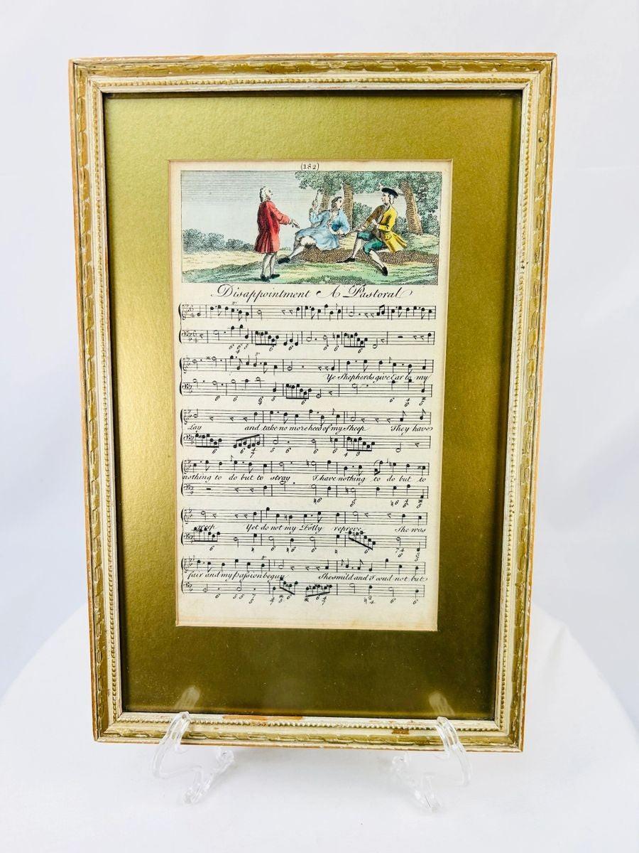 Georgian era 18th-century engraved sheet music with hand-colored pastoral scene, depicting figures in a countryside setting above musical notation; mounted in a gilt frame with velvet backing, showcasing fine period engraving, early music history, and decorative art appeal.