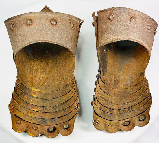 Pair of antique Gothic-style metal gauntlets with articulated plates and etched detailing, shown upright on a white background.