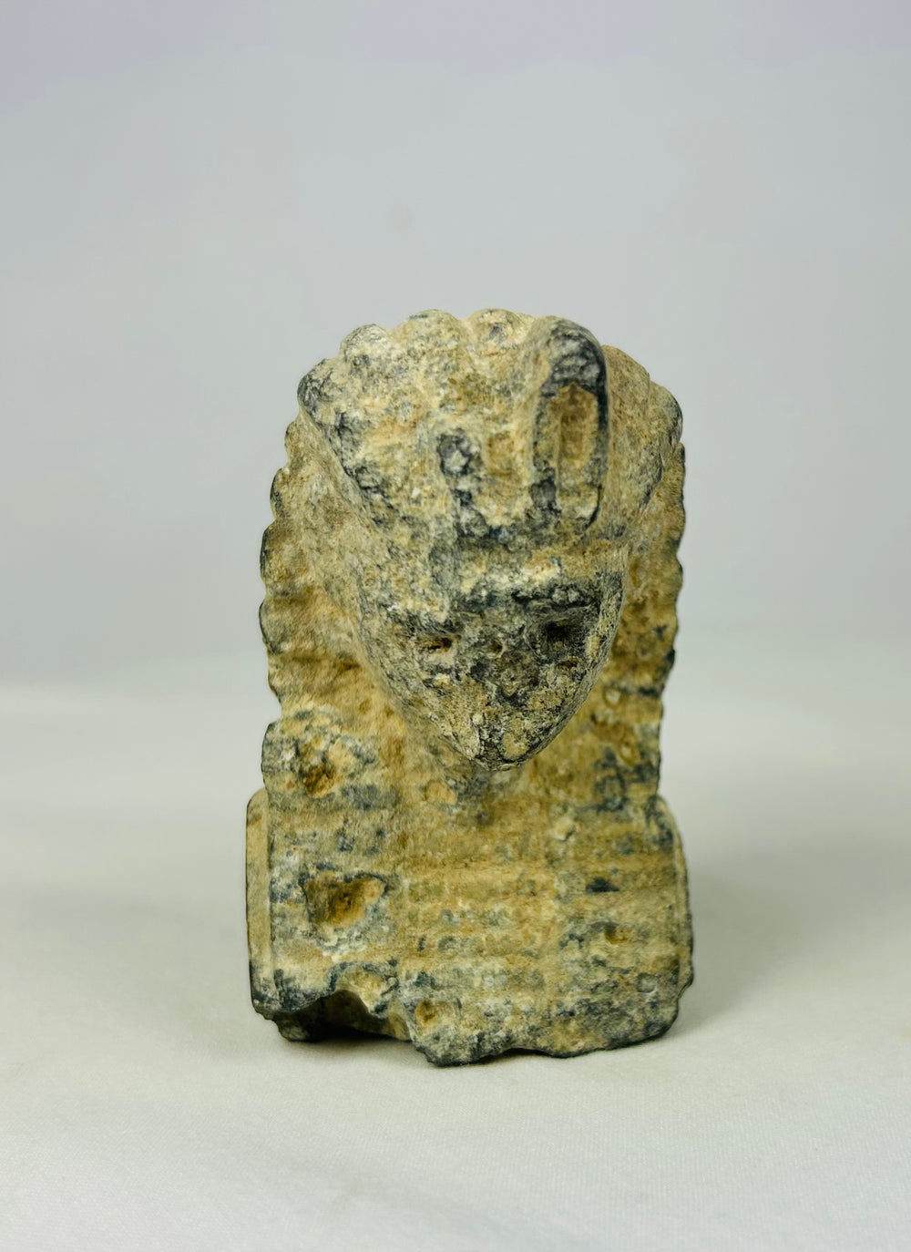 Carved limestone pharaoh head with nemes headdress and uraeus cobra motif, European Grand Tour collectible from circa 1800–1920, displayed on a neutral background.