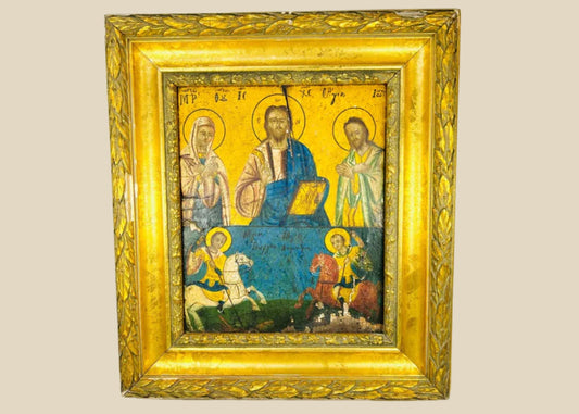 Greek Orthodox icon painting with Christ Pantocrator, Virgin Mary, and St. John the Baptist in the upper register, St. George slaying the dragon, and St. Demetrius on horseback in the lower register, painted in tempera with gold background, framed in ornate gilt foliate frame, photographed on a white background.