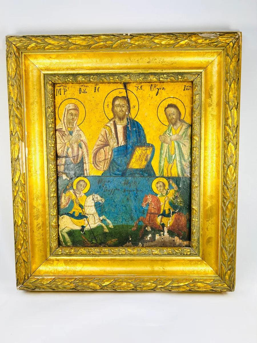 Greek Orthodox icon painting with Christ Pantocrator, Virgin Mary, and St. John the Baptist in the upper register, St. George slaying the dragon, and St. Demetrius on horseback in the lower register, painted in tempera with gold background, framed in ornate gilt foliate frame, photographed on a white background.