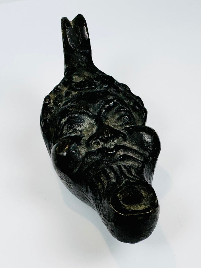 Nineteenth-century European oil lamp in the form of a grotesque mask influenced by classical and Renaissance traditions.