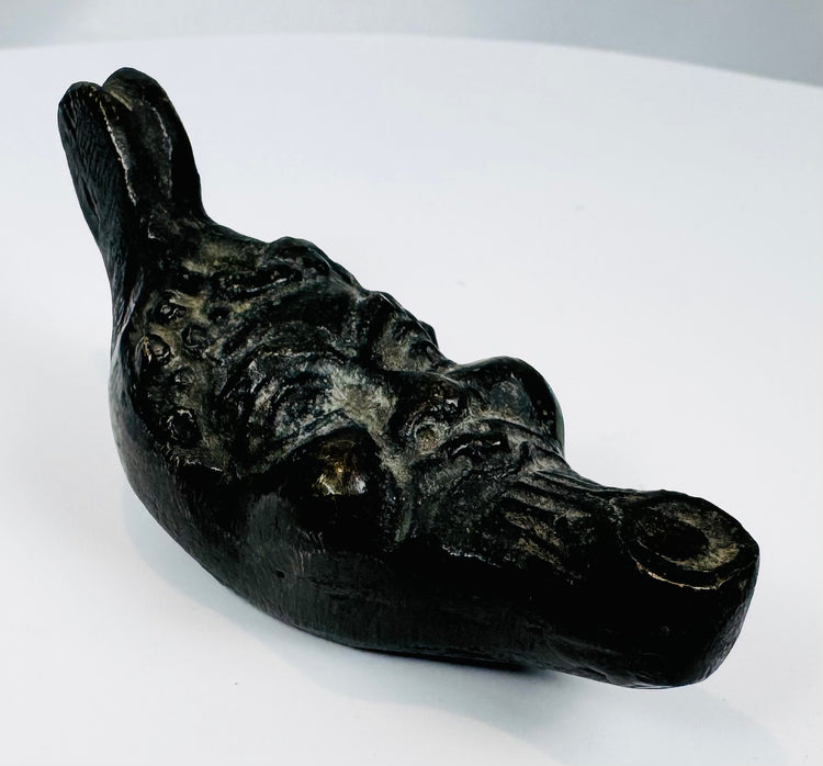 Antique mythological mask oil lamp featuring exaggerated eyes, beard, and cast metal craftsmanship.