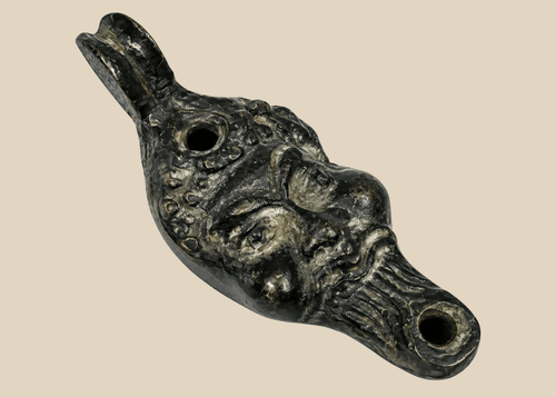 Antique grotesque satyr-form oil lamp with cast metal construction and dark aged patina, Europe, 19th century.