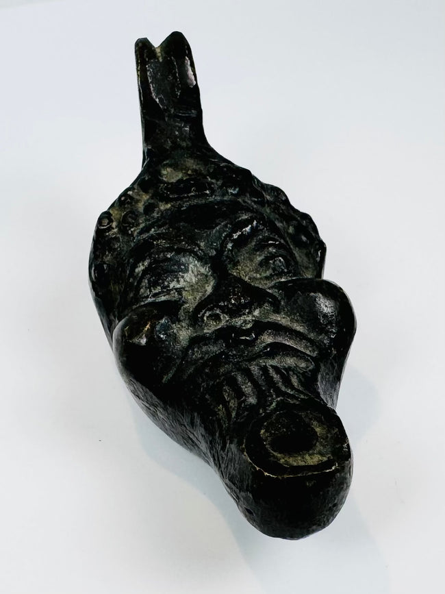 Nineteenth-century European oil lamp in the form of a grotesque mask influenced by classical and Renaissance traditions.