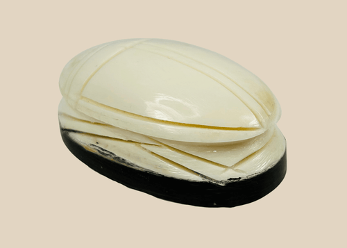 Antique East Asian carved bone scarab talisman on dark oval base, late 19th to early 20th century protective charm