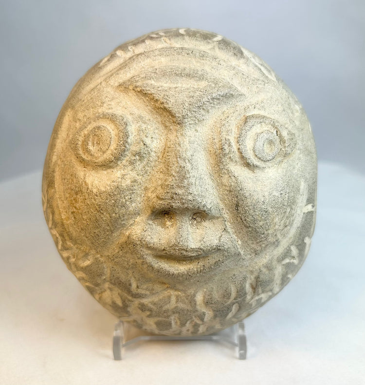 Close-up of carved stone face highlighting textured surface and facial features
