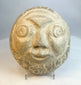 Close-up of carved stone face highlighting textured surface and facial features