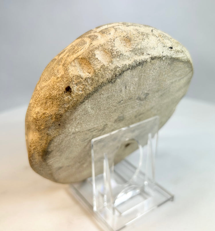 Back view of carved stone sculpture showing smooth weathered surface