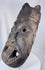 Hand-carved West African spirit mask with expressive facial expression and ceremonial sculptural form.