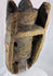 Carved hardwood African mask with powerful expression, worn patina, and ethnographic character.