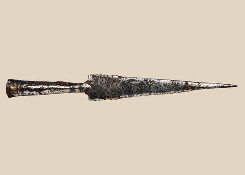 Forged iron spearhead from Europe, Iron Age to Early Medieval period (circa 1st millennium CE), featuring a scalloped-edge blade, socketed base, and historic mixed-metal brazed repair. Natural patina and surface texture reflect centuries of use, craftsmanship, and cultural significance as both a functional weapon and symbol of status.