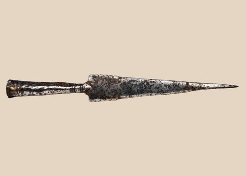 Forged iron spearhead from Europe, Iron Age to Early Medieval period (circa 1st millennium CE), featuring a scalloped-edge blade, socketed base, and historic mixed-metal brazed repair. Natural patina and surface texture reflect centuries of use, craftsmanship, and cultural significance as both a functional weapon and symbol of status.