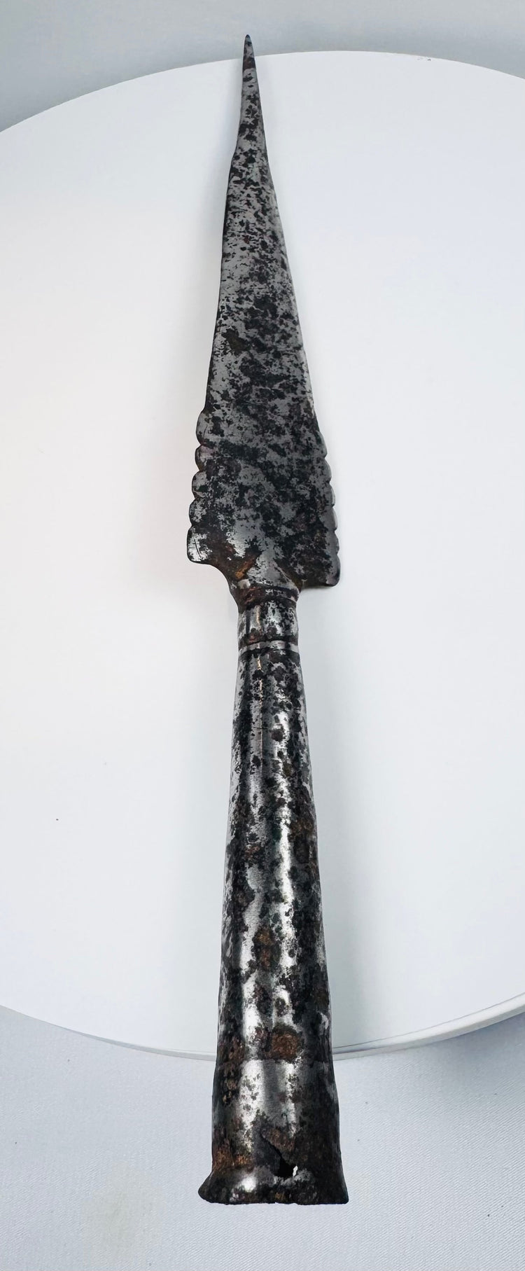 Detailed view of ancient European spearhead with scalloped-edge iron blade and mixed-metal repair