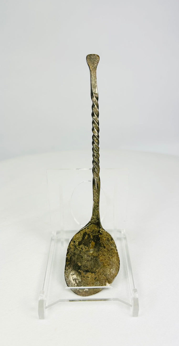 Hand-forged bronze spoon with twisted handle on white background, circa 2nd century AD