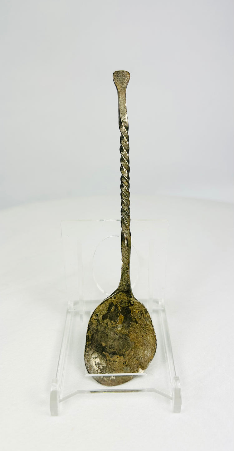 Hand-forged bronze spoon with twisted handle on white background, circa 2nd century AD