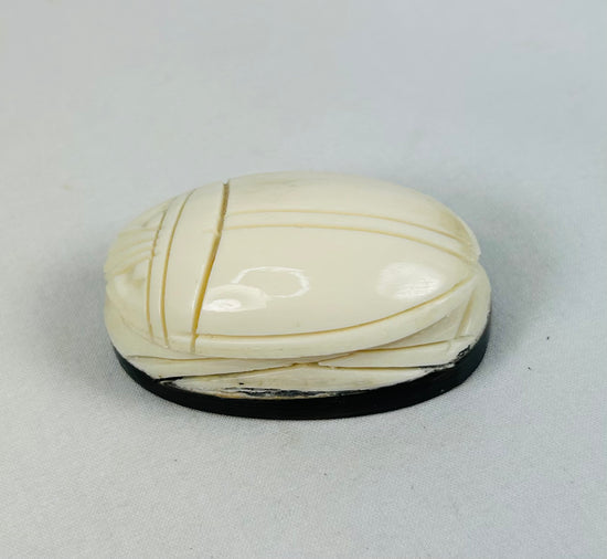 Hand-carved East Asian scarab-form talisman mounted on dark oval base