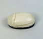 Hand-carved East Asian scarab-form talisman mounted on dark oval base
