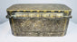 End profile of an antique Filipino betel box showing the raised lid, decorative metalwork, and side-mounted suspension ring.