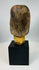 Carved Christ head mounted on display base with aged surface