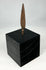 Side profile of leaf-blade iron arrowhead mounted on museum-style black stand