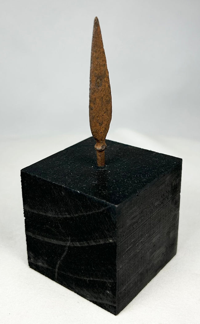 Authentic ancient iron projectile point showing aged patina and archaeological surface texture