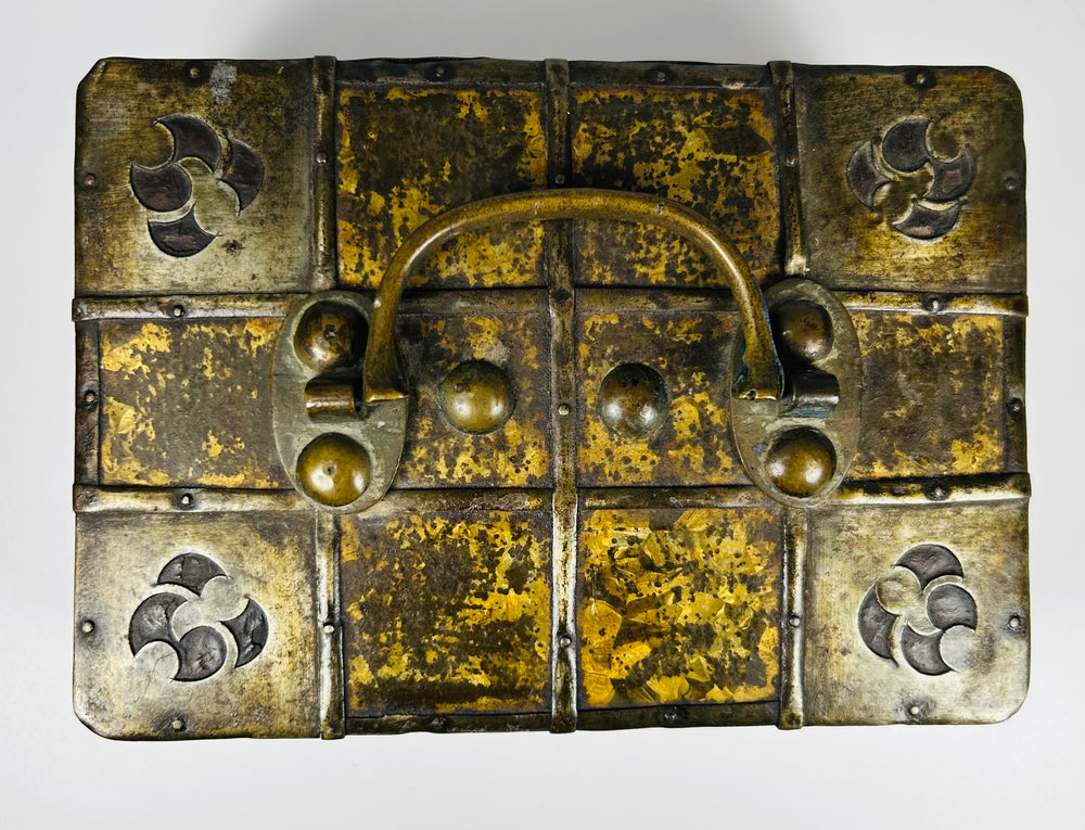 Antique iron-bound valuables chest with arched carrying handle, gilt patterned panels, and original working key.