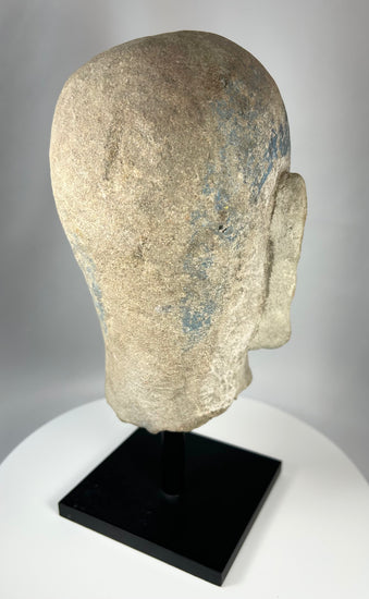 Historic Chinese temple sculpture fragment of a Luohan head with traces of painted decoration.