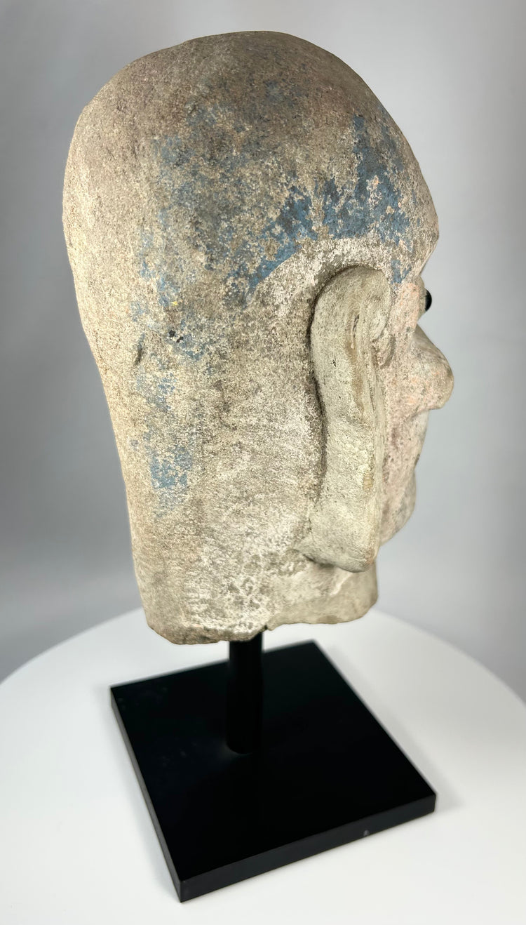 Qing Dynasty carved stone Luohan head with pronounced brows and expressive facial features.