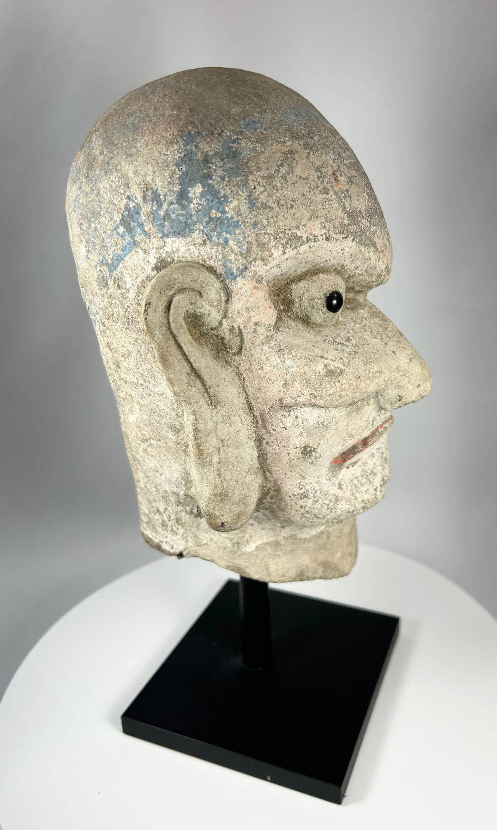 Chinese Buddhist Arhat stone head sculpture with remnants of original temple polychrome.