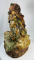 Chinese ceramic figure of Jigong the Mad Monk seated on rocky base with mottled glaze.