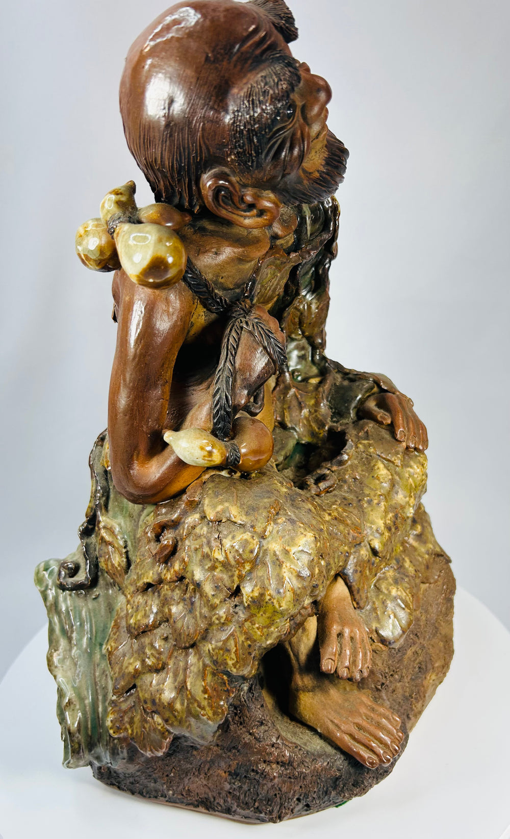 Chinese glazed pottery statue of Jigong with vine leaf cloak and gourd attributes.