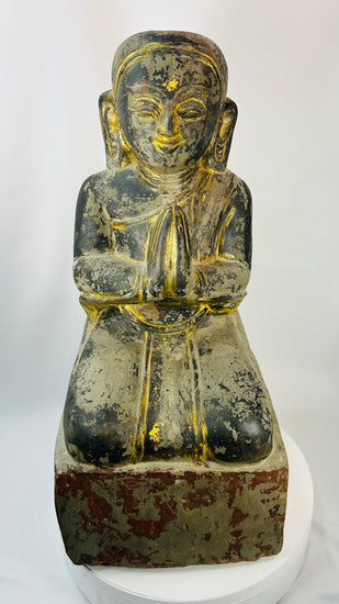 Burmese Buddhist kneeling attendant sculpture with hands pressed together in prayer.