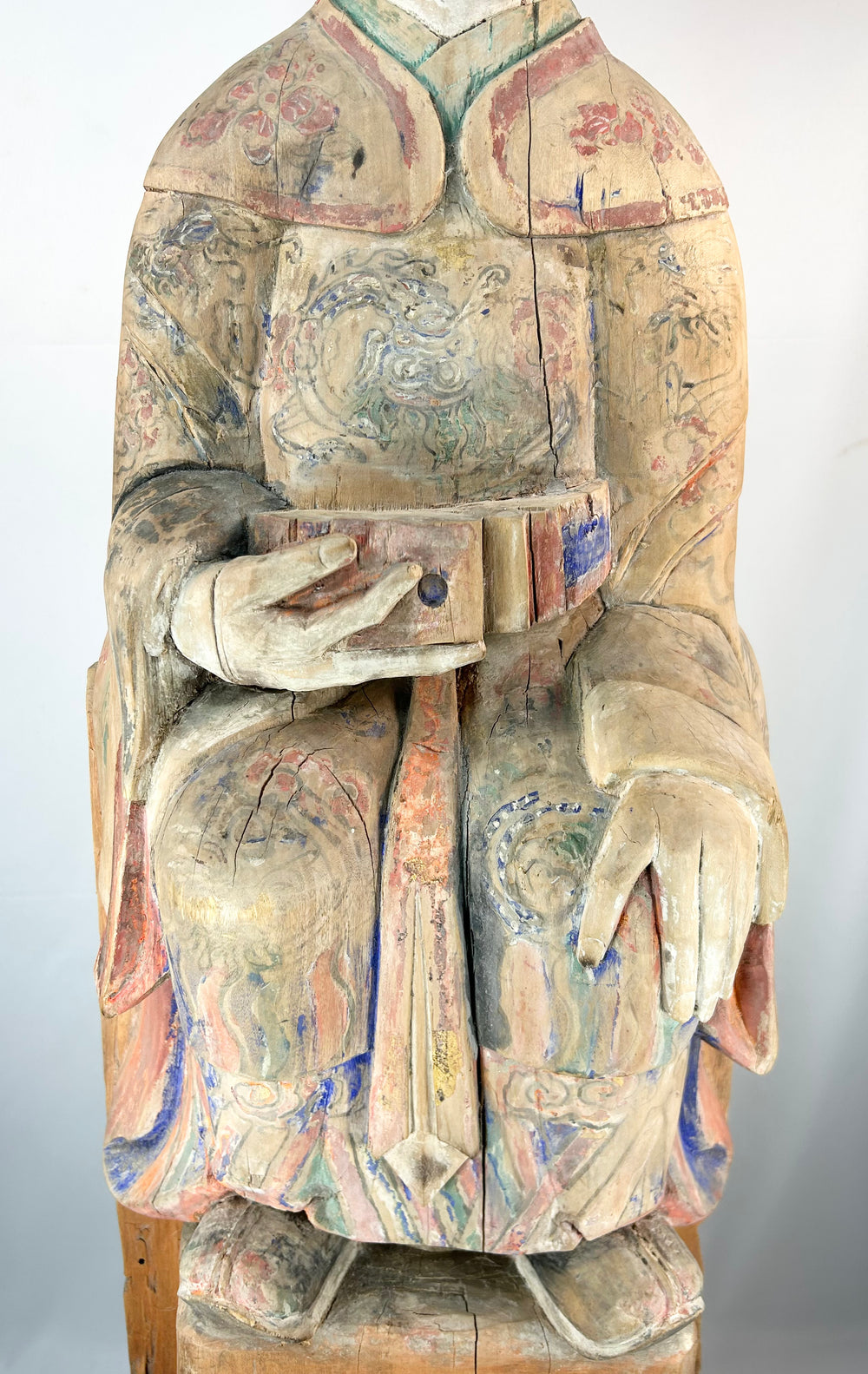 Chinese shrine sculpture of a seated court official with colorful painted decoration.