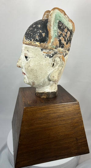 Chinese temple bust of a scholar-official with black ceremonial hat and red lips.