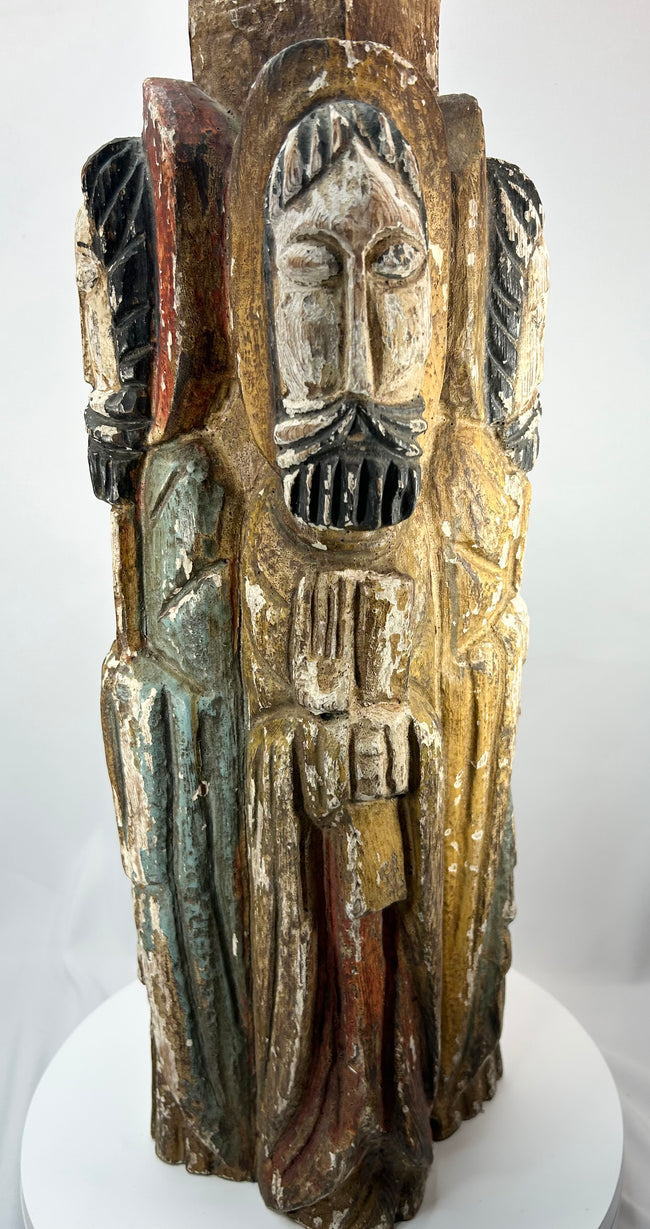Historic Spanish Colonial church carving depicting four saints around a central column.