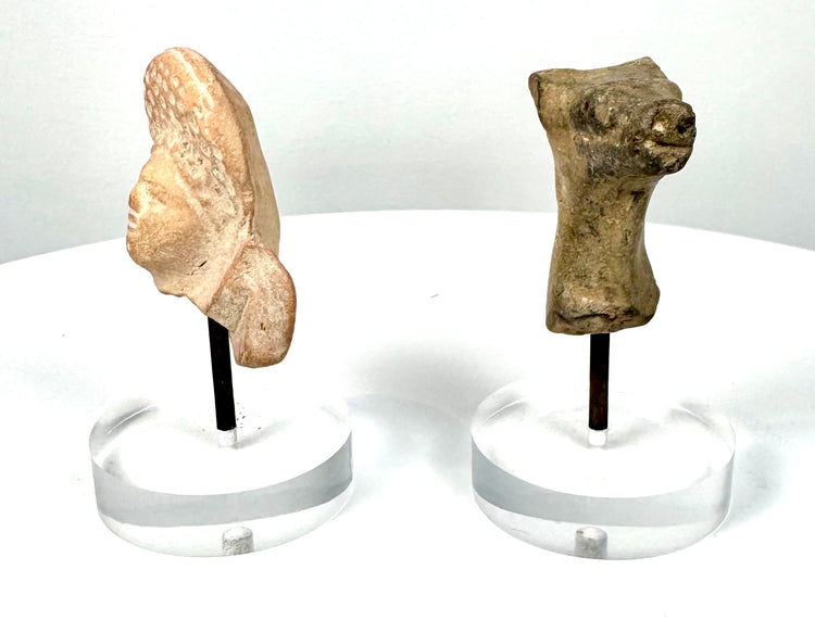 Ancient Roman female bust fragment exhibiting closely spaced circular hair impressions, surface erosion, and partially preserved neck and shoulder details.