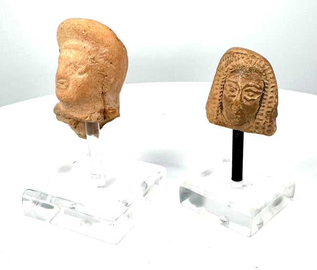 East Greek terracotta female protome with patterned vertical hair locks, arched eyebrows, and stylized facial features from the Archaic–Classical periods.