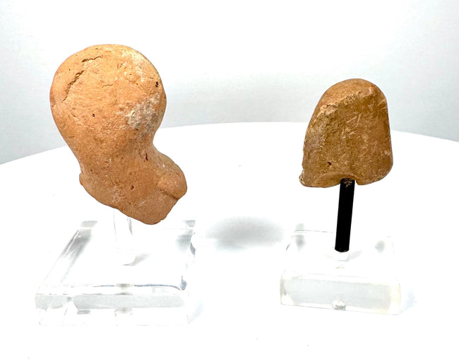 East Greek female protome displaying closely arranged hair impressions, weathered buff-coloured terracotta, and dark deposits within recessed details.