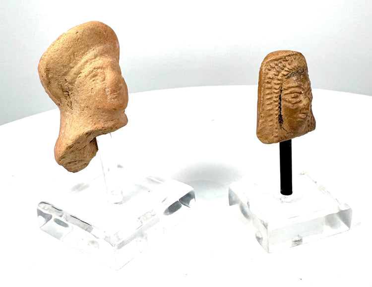 Pair of Etruscan and East Greek terracotta sculpture fragments exhibiting aged ceramic surfaces, facial modelling, and traditional Mediterranean artistic characteristics.