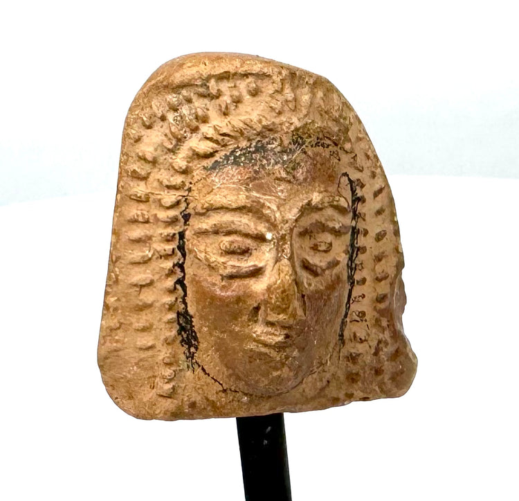 Etruscan terracotta female head from the 4th century BCE, featuring a broad rounded headdress, softly modelled facial features, and reddish-orange clay.