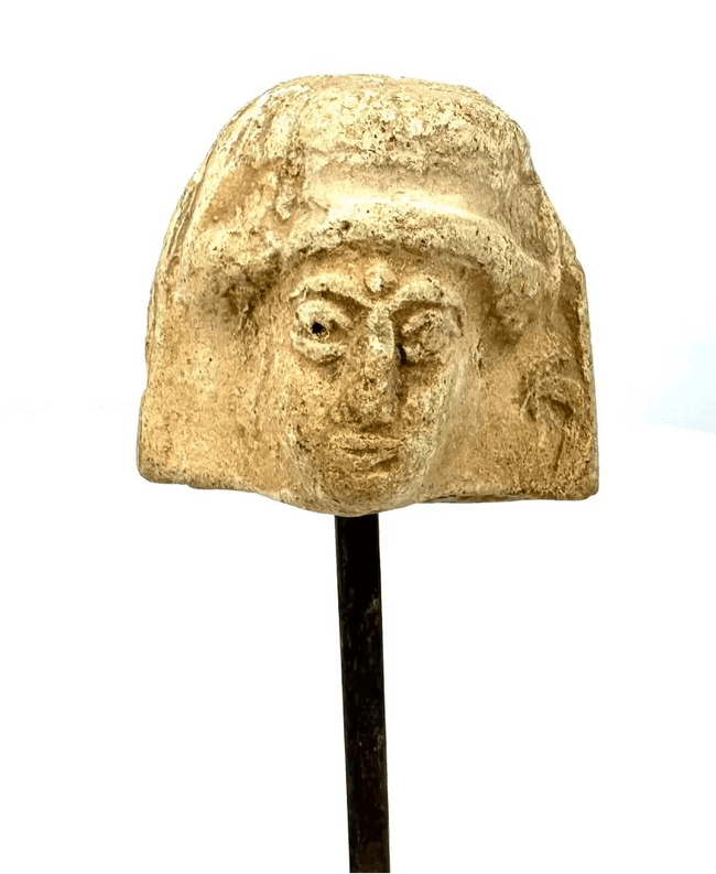 Ancient Greek terracotta female protome with a rectangular plaque-like form, prominent horizontal upper border, and carefully modelled facial features.