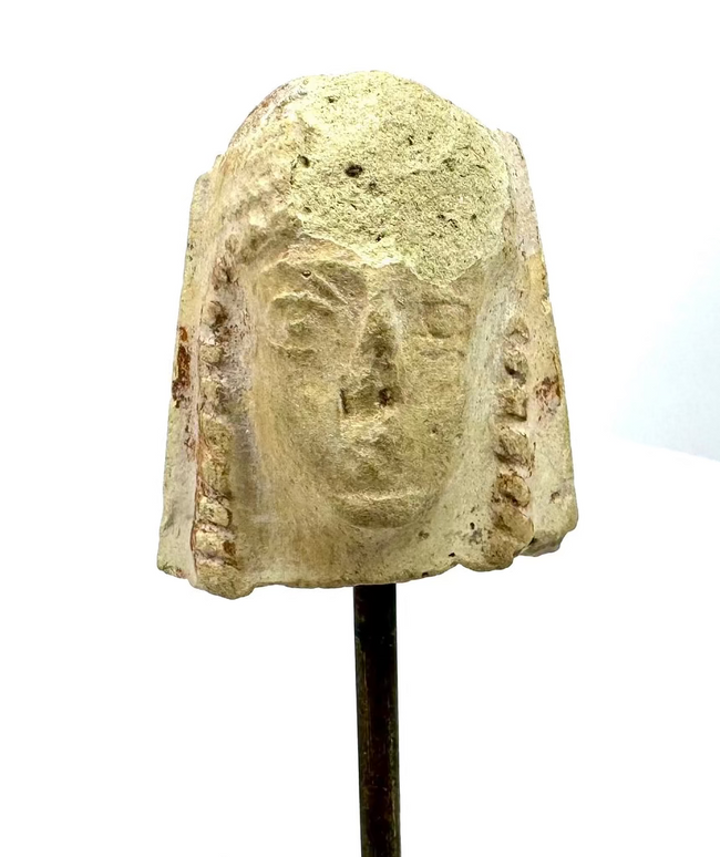 Ancient Greek female terracotta protome featuring a rounded headdress, elongated facial features, and heavily weathered pale cream-coloured clay.