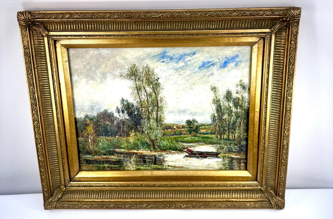 Early 20th-century landscape oil painting with a reddish-brown clothed figure in a wooden rowing boat surrounded by trees and grassy riverbanks.