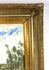 Vintage oil on canvas painting featuring tall riverside trees, rolling green fields, soft white clouds, and an expansive blue sky.
