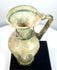 Ancient Byzantine blown glass vessel displaying an elongated neck, rounded rim, vertical body ribbing, and pale green glass construction.